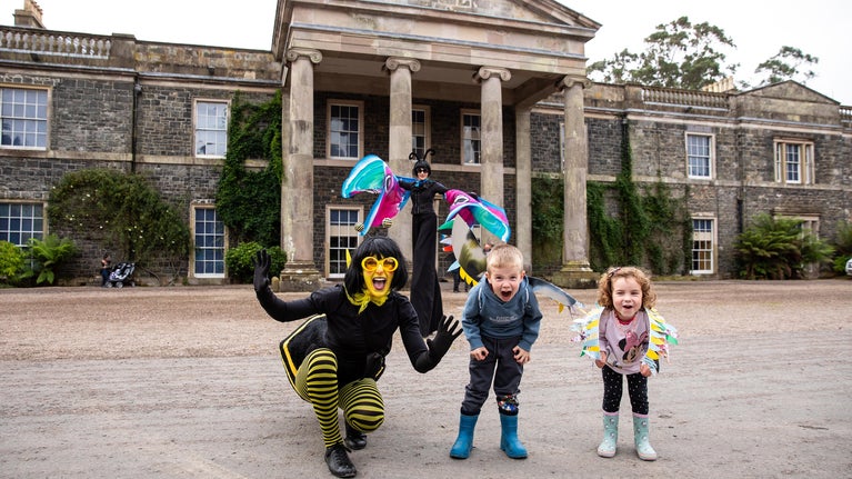 Entertainer and children standing outside Mount Stewart House